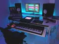 Studio z syntezatorami, kontrolerami i monitorami. Idealne miejsce do tworzenia muzyki, spełniające **fl studio wymagania**.
