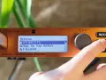 Palec naciska przycisk na urządzeniu cymatic audio uTrack 24, wyświetlającym listę odtwarzania.