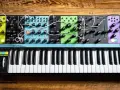 Moog Matriarch, półmodularny syntezator analogowy, z klawiaturą i licznymi pokrętłami i złączami, gotowy do tworzenia dźwięków.