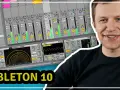 Uśmiechnięty mężczyzna na tle ekranu z programem Ableton 10. Idealny do nauki, jak tworzyć muzykę w Ableton kurs.
