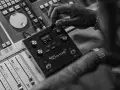 Dłoń dostraja urządzenie Antares Auto-Tune na konsoli mikserskiej, tworząc idealny dźwięk.