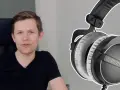 Mężczyzna w czarnej koszulce obok słuchawek do mixu Beyerdynamic DT 770 PRO.