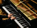 Dłonie muzyka grające na fortepianie, którego wnętrze z widocznymi strunami i młoteczkami przypomina zaawansowany piano vst.