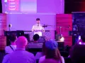 Prezentacja muzyczna z efektami, jak spring reverb. Mężczyzna mówi do mikrofonu, na ekranie widać program do produkcji muzyki.