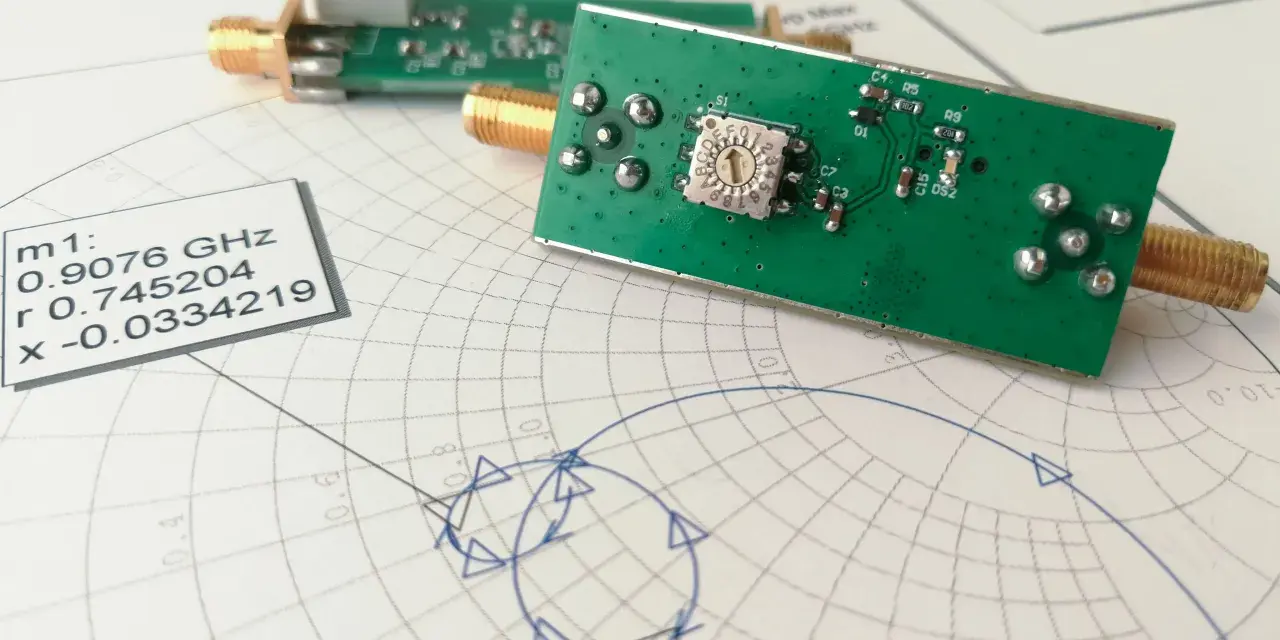 Elektronika na wykresie Smitha, analizująca impedancję. Widać złącza SMA i dane pomiarowe.