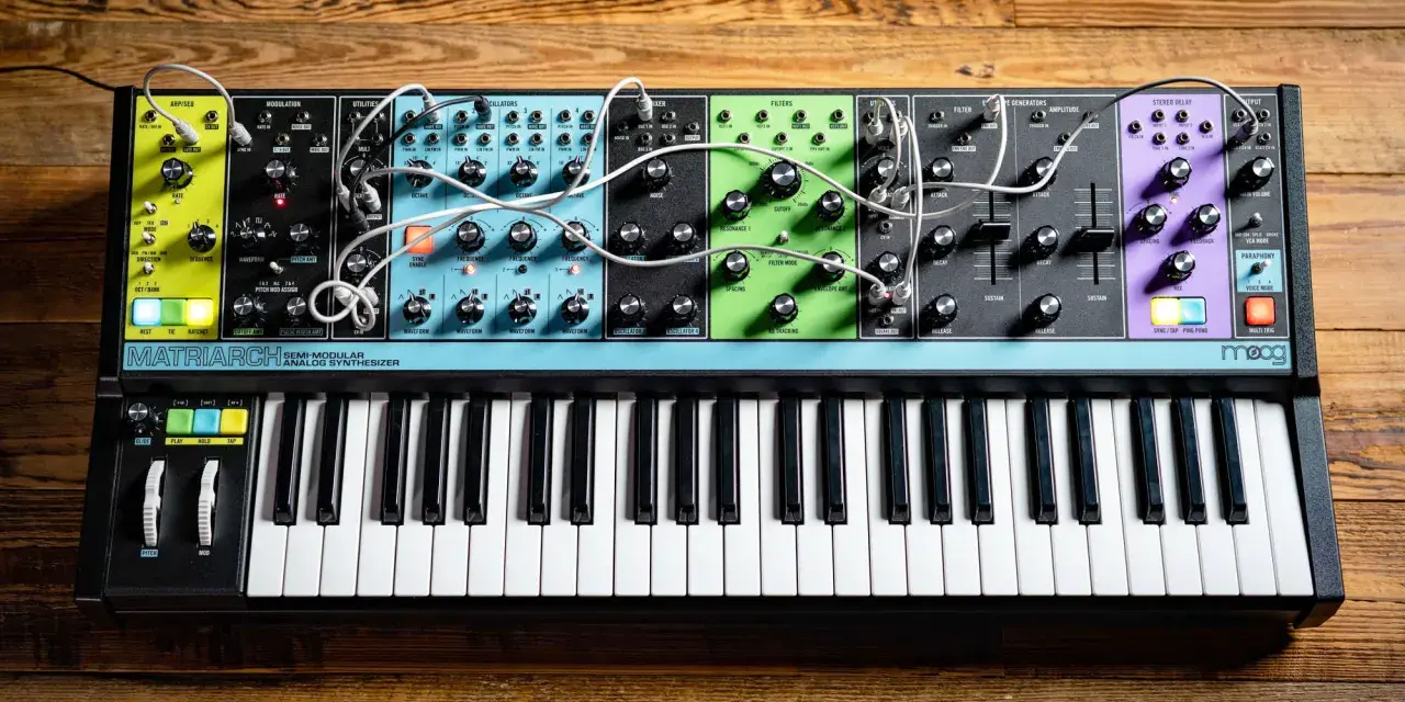 Moog Matriarch, półmodularny syntezator analogowy, z klawiaturą i licznymi pokrętłami i złączami, gotowy do tworzenia dźwięków.
