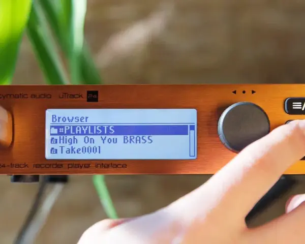 Palec naciska przycisk na urządzeniu cymatic audio uTrack 24, wyświetlającym listę odtwarzania.