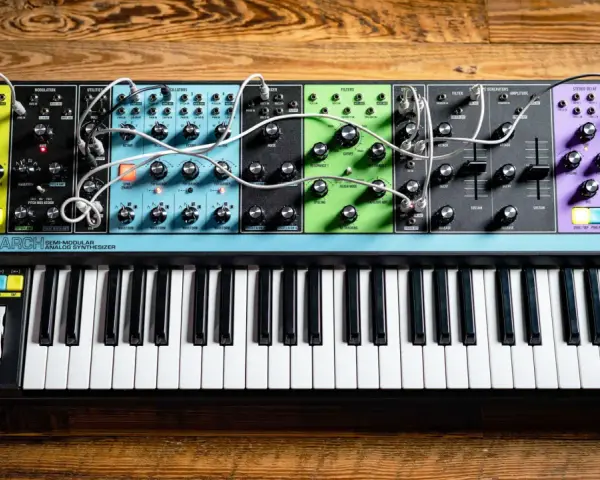 Moog Matriarch, półmodularny syntezator analogowy, z klawiaturą i licznymi pokrętłami i złączami, gotowy do tworzenia dźwięków.