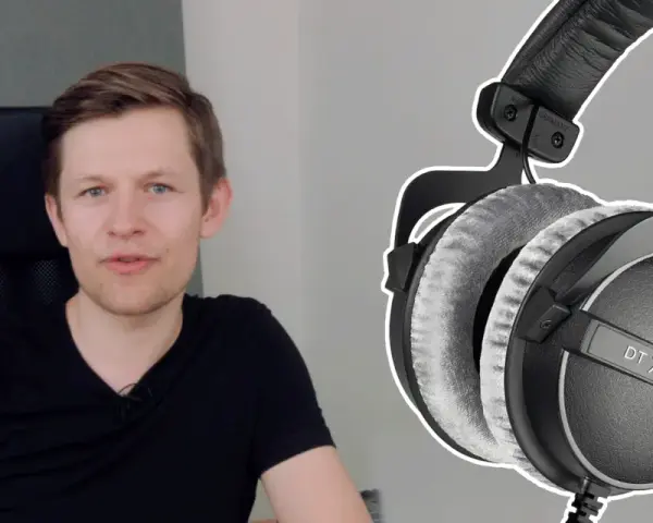 Mężczyzna w czarnej koszulce obok słuchawek do mixu Beyerdynamic DT 770 PRO.