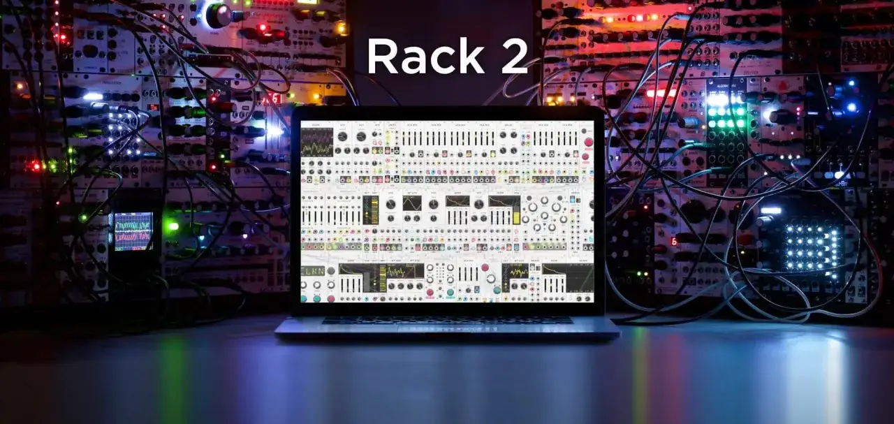 Komputer z otwartym VCV Rack 2 na tle modularnego syntezatora.