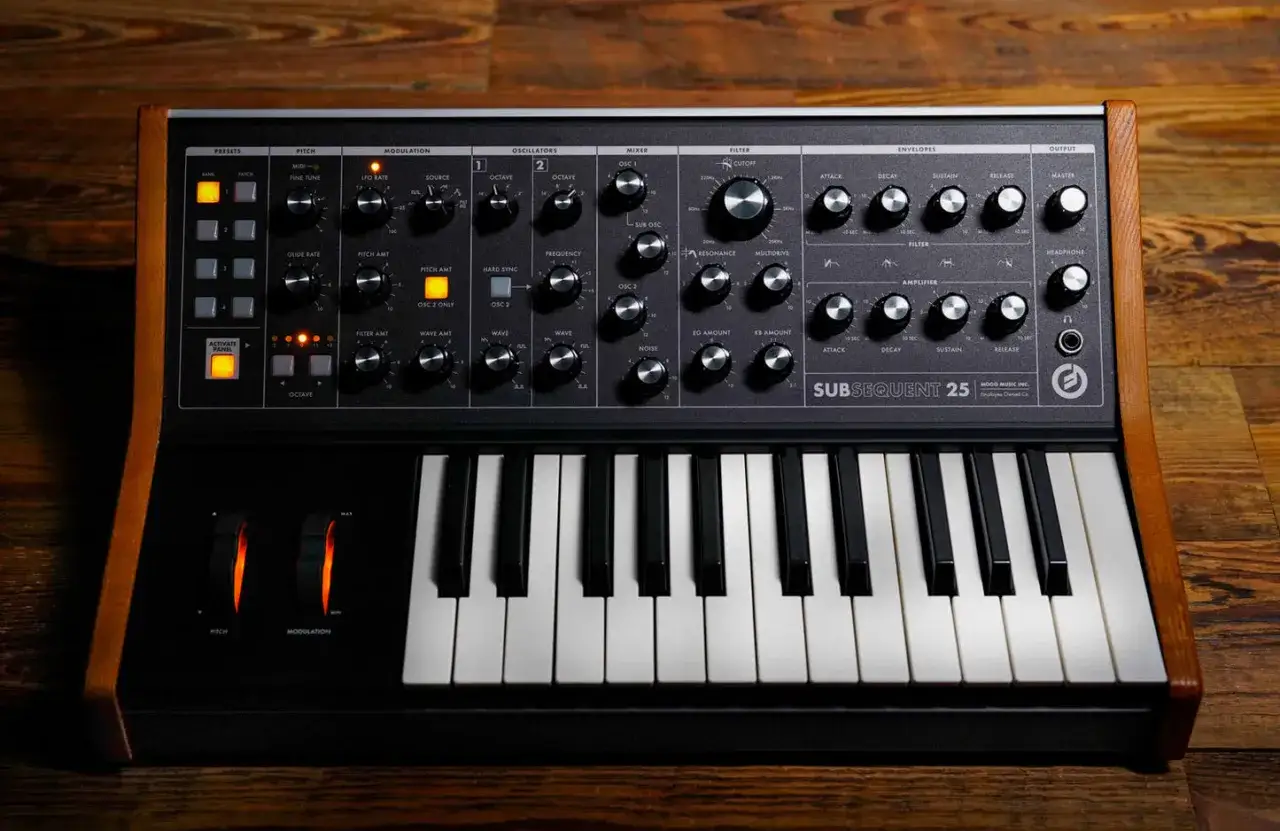 Czarny syntezator Moog Subsequent 25 z drewnianymi panelami bocznymi, klawiaturą i licznymi pokrętłami do tworzenia dźwięków.